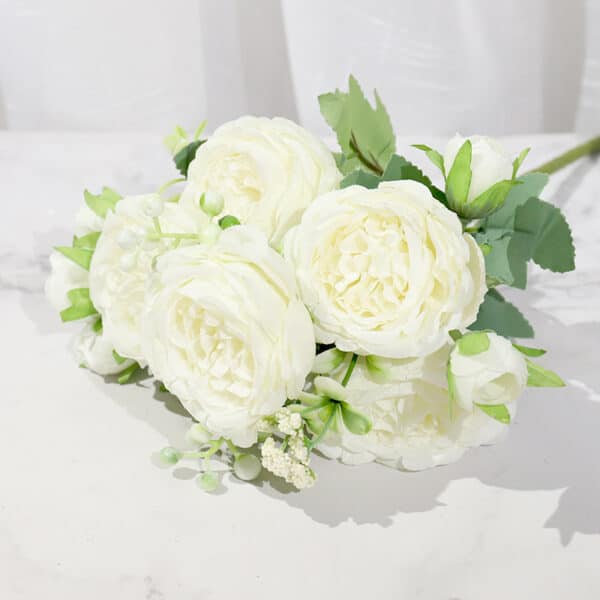 Bouquet di peonie bianche su un tavolo bianco dietro una tenda bianca
