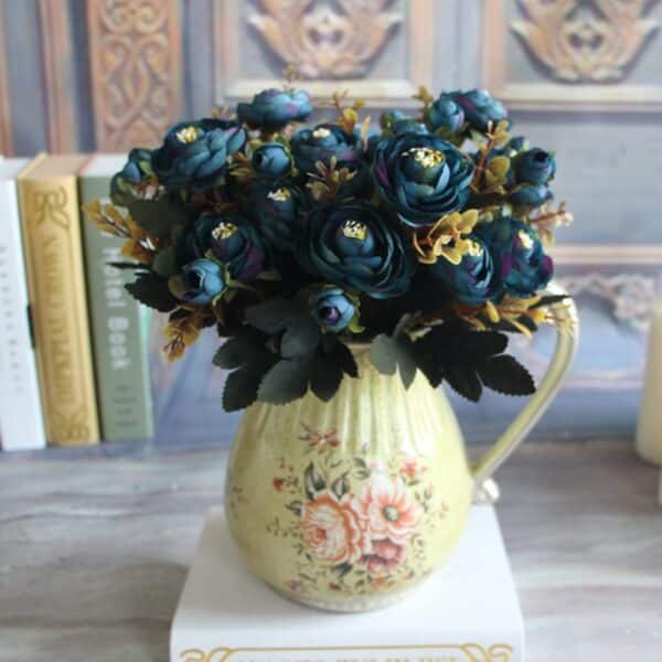 Un bouquet di peonie blu in un vaso giallo su un tavolo.