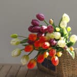 Bouquet di tulipani in un cesto di vimini su un tavolo di legno