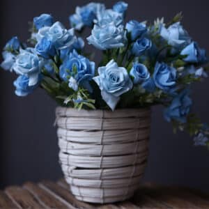 Bouquet di rose blu in un vaso grigio.