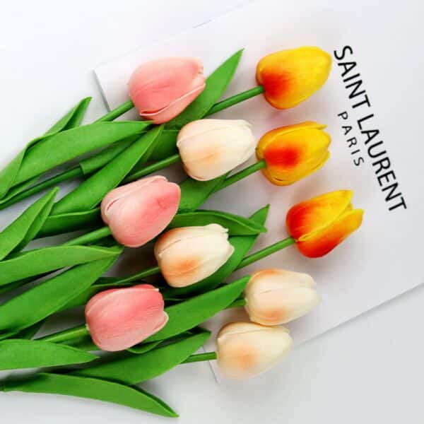 Tulipani bianchi, rosa e arancioni su una rivista bianca