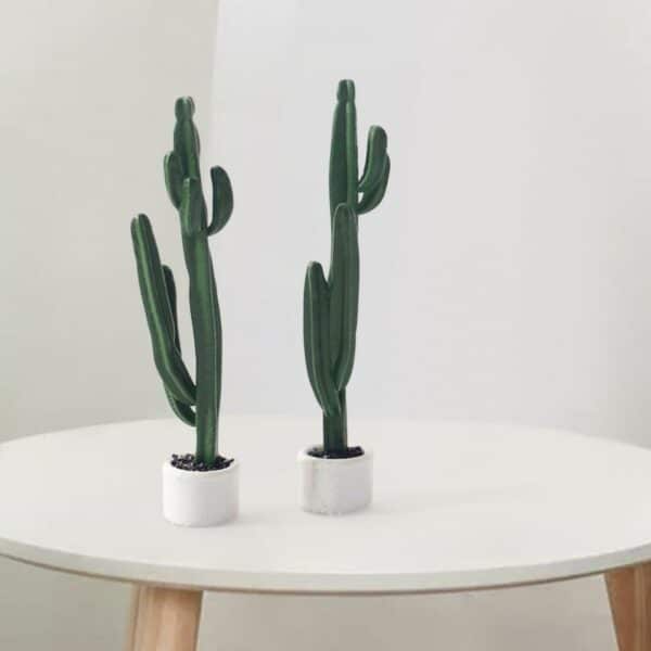 Foto di due mini cactus artificiali su un tavolino da caffè bianco