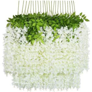 Su uno sfondo bianco, numerosi rami di glicini artificiali bianchi e spessi in piena fioritura.