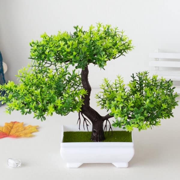 Pianta bonsai artificiale in plastica verde in vaso bianco.