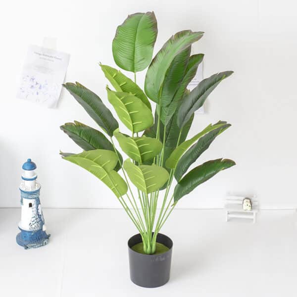 foto di un vaso con foglie di banano artificiali.