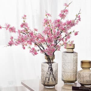 Fiori di ciliegio in un vaso su un tavolo.