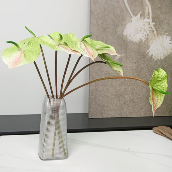 Stelo artificiale di Anthurium multicolore in un vaso trasparente.