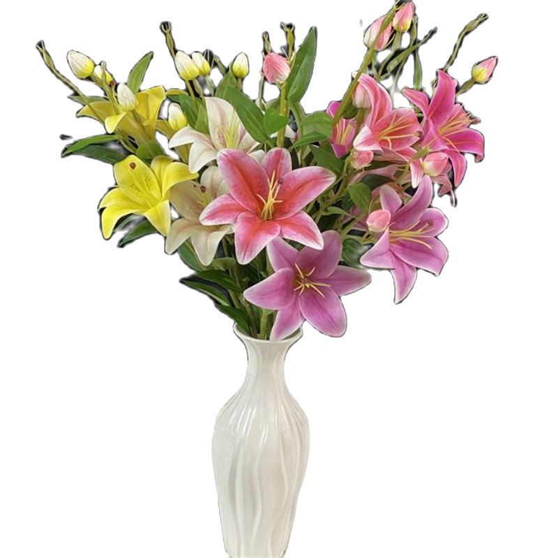 Vaso pieno di fiori di giglio artificiali su sfondo bianco.