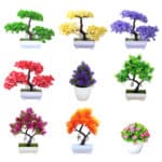 Tante piante bonsai artificiali di colori diversi su uno sfondo bianco